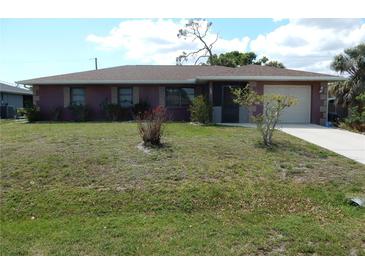 Charming single-story home featuring an attached garage and well-maintained front yard at 582 Reading Nw St, Port Charlotte, FL 33952