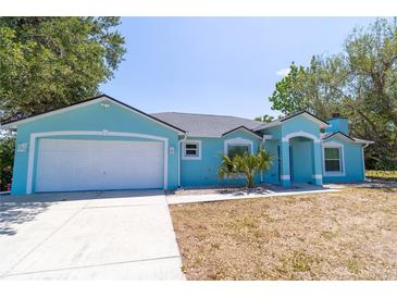 Charming single-story home with a two-car garage and light blue exterior paint at 6308 Grove Blvd, Punta Gorda, FL 33982