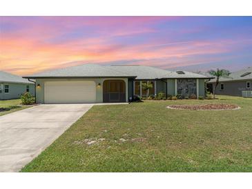 Charming single-story home with a well-manicured lawn and a two-car garage at 1069 Fergus Ln, Punta Gorda, FL 33983