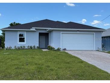 Charming single-story home with a manicured lawn and attached two-car garage at 198 Arch Dr, Rotonda West, FL 33947