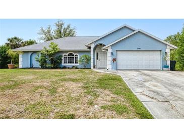 Charming, one story home with a white garage door, arched entry, and well-maintained lawn at 2685 Nanette Ln, North Port, FL 34286