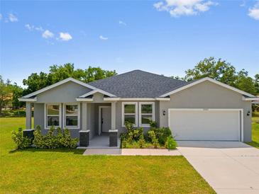 Charming single-story home with a well-manicured lawn, attached two-car garage, and inviting front entrance at 27263 Deep Creek Blvd, Punta Gorda, FL 33983