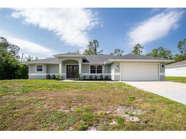 Charming single-story home features a two-car garage and neatly manicured lawn at 5611 Ganyard Ave, North Port, FL 34291