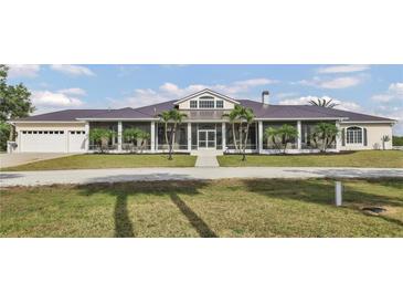 Spacious ranch-style home with a metal roof, large screened porch, and a well-manicured front lawn at 7200 Riverside Dr, Punta Gorda, FL 33982
