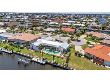 Aerial view of a luxury canal-front property with a boat dock and a sparkling swimming pool at 810 Napoli Ln, Punta Gorda, FL 33950