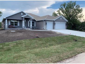 Beautiful single-story home featuring a 2-car garage, well-manicured lawn, and neutral-colored stucco finish at 112 Cougar Way, Rotonda West, FL 33947
