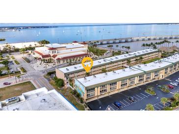 An aerial view showcases the waterfront condos, bridge, and nearby ocean at 150 Harborside Ave # 134, Punta Gorda, FL 33950