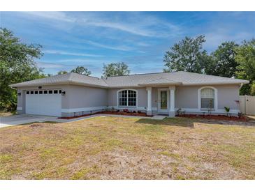 Charming single-story home showcasing a well-maintained lawn, a two-car garage, and welcoming front entrance at 1773 Portage St, North Port, FL 34287