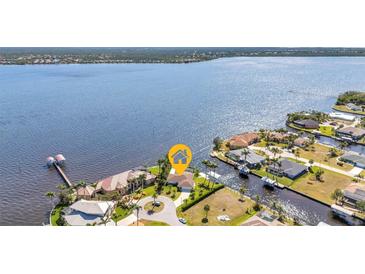 Aerial view of waterfront home with lush landscaping and private dock at 3016 Curry Ter, Port Charlotte, FL 33981