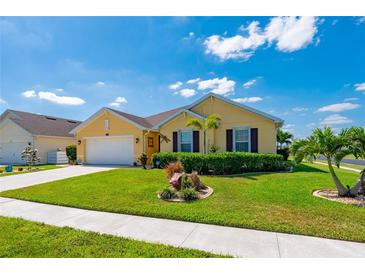 Well-manicured lawn and tidy flowerbeds surround this charming single-story home at 7501 Mikasa Dr, Punta Gorda, FL 33950