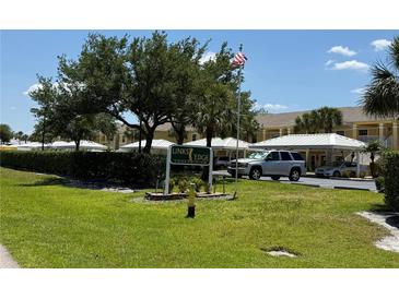 Links Edge Condominium exterior view of the complex entrance, sign, and well-maintained landscaping on a sunny day at 1295 Saxony Cir # 2101, Punta Gorda, FL 33983