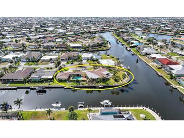 Waterfront home on a canal with a pool and dock, surrounded by lush landscaping at 1796 Boca Raton Ct, Punta Gorda, FL 33950