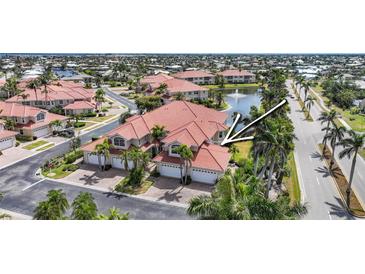 Stunning waterfront villa with a red tile roof, lush landscaping, and a three-car garage at 196 Tarpon Cove Blvd # 722, Punta Gorda, FL 33950