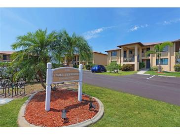 Well-maintained condo complex with lush landscaping, a community sign and ample parking on a clear sunny day at 3221 White Ibis Ct # D2, Punta Gorda, FL 33950