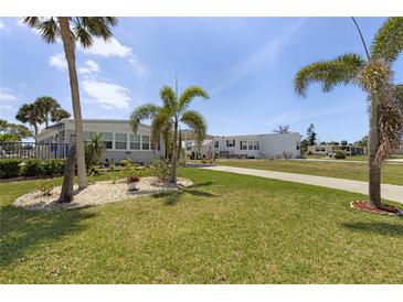 Charming single-story home with beautiful landscaping, palm trees and a well-maintained lawn at 3305 Blue Jay Ln, Englewood, FL 34224