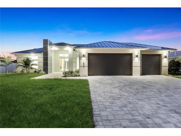 Stunning modern home boasts clean lines, a metal roof, a spacious driveway, and a manicured front lawn at 10522 Riverside Rd, Port Charlotte, FL 33981