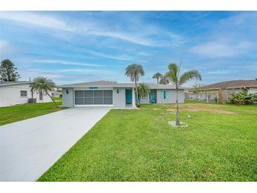Charming single-story home with a well-manicured lawn and mature palm trees at 1756 Elinor Pl, Englewood, FL 34223