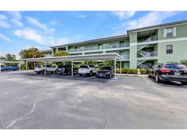 Exterior view of assigned parking and a stairway in front of this lovely, multi-story condo building on a sunny day at 2020 Willow Hammock Cir # 302, Punta Gorda, FL 33983
