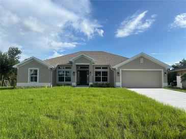 Charming single-story home with neutral paint, manicured lawn, and an attached two-car garage at 23245 Jules Ave, Port Charlotte, FL 33980