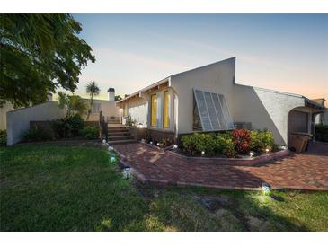 Charming home exterior with a brick path, lush landscaping, and a glimpse of the cozy front porch at 25188 Marion Ave # 10, Punta Gorda, FL 33950