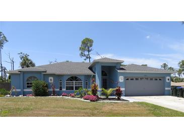 Charming single-Gathering home featuring a well-manicured lawn, mature landscaping and a two-car garage at 4309 Badali Rd, North Port, FL 34286