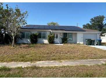 Single-story home featuring solar panels on the roof and a well-maintained front yard at 8782 La Boca Ave, North Port, FL 34287