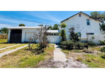 Exterior view of a home with a detached garage and ample yard space at 899 S Broadway, Englewood, FL 34223