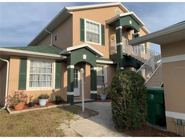 Inviting two-story home featuring green shutters, a matching roof, and a stairway to a private entrance at 224 Boundary Blvd # 224L, Rotonda West, FL 33947