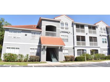 Exterior view of condo building with gray facade, red tile roof, and well-maintained landscaping at 18001 Richmond Place Dr # 636, Tampa, FL 33647