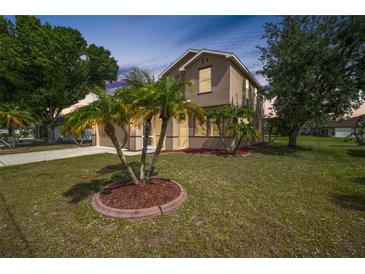 Inviting two-story home with a well-manicured lawn and palm tree landscaping at 26100 Paysandu Dr, Punta Gorda, FL 33983