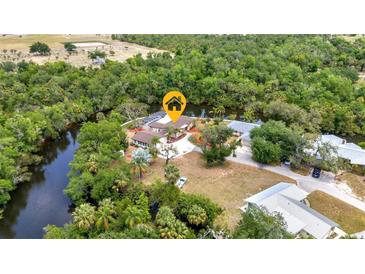 Stunning aerial view of a waterfront home with a private pool nestled among lush greenery at 3400 Allapatchee Dr, Punta Gorda, FL 33950