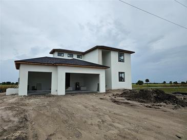 Modern two-story home featuring a white exterior, black trim, and an attached two-car carport at 7 Sunflower Dr, Placida, FL 33946