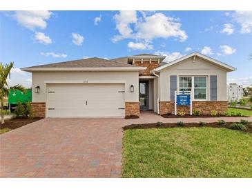 Charming single-story home with a two-car garage, brick accents, and a well-manicured lawn at 1132 Moss Cove Ct, Port Charlotte, FL 33953