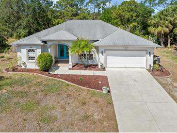 Well-maintained home with a concrete driveway, two-car garage, and landscaped front yard at 1313 Wise Dr, North Port, FL 34286