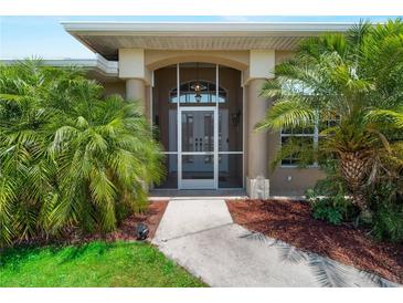 Inviting front entrance with decorative pillars and well-manicured landscaping featuring lush palms at 2288 Prague Ln, Punta Gorda, FL 33983