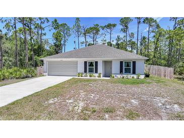 Charming single-story home featuring a neutral palette, an attached two-car garage, and a well-maintained front yard at 23470 Burlingame Ave, Punta Gorda, FL 33980