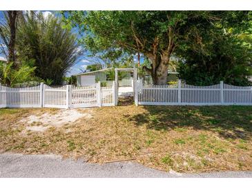 Charming home with a white picket fence and mature trees providing shade and privacy at 31037 Prairie Creek Dr, Punta Gorda, FL 33982