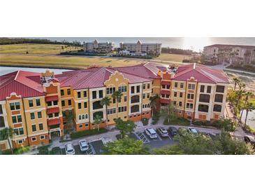 Aerial view of condos with red roofs, palm trees and parking lot at 95 Vivante Blvd # 9524, Punta Gorda, FL 33950