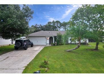 Charming single-story home with a well-manicured lawn, mature trees, and a convenient two-car garage at 1372 Annette St, Punta Gorda, FL 33980