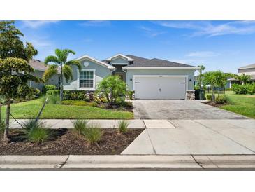 Charming single-story home with well-manicured lawn, lovely landscaping, and a paved driveway leading to a two-car garage at 17459 Palmetto Pass Ln, Punta Gorda, FL 33982