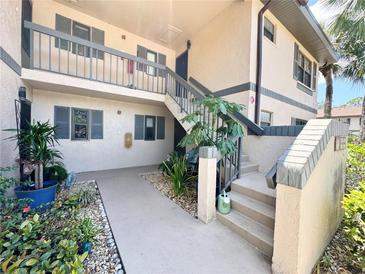 Inviting exterior of condo with well-maintained landscaping and a stairway to the second level at 19505 Quesada Ave # Ii201, Port Charlotte, FL 33948