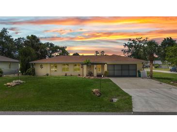 Charming home boasts a well-maintained lawn and a neutral color scheme under a colorful sunset sky at 20355 Mount Prospect Ave, Port Charlotte, FL 33952