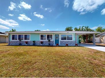 Charming single story home featuring a quaint carport, cheerful exterior color scheme, and low maintenance landscaping at 20407 Albury Dr, Port Charlotte, FL 33952
