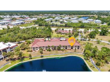 Beautiful aerial view of the condo complex, showcasing the landscaping, nearby pond, and well-maintained grounds at 23465 Harborview Rd # 1002, Punta Gorda, FL 33980