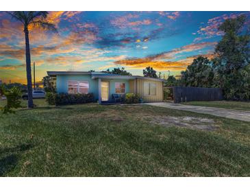 Charming single-story home featuring colorful exterior, well-manicured lawn, and mature trees at 3927 Vasco St, Punta Gorda, FL 33950