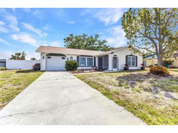 Charming single-story home with a well-manicured lawn, attached garage, and inviting front entrance at 6753 Thorman Rd, Port Charlotte, FL 33981