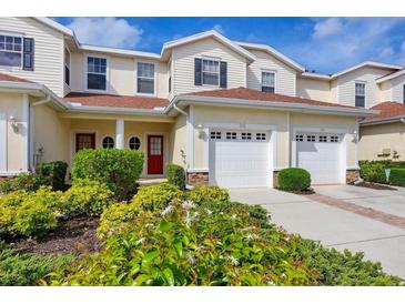 Inviting townhouse showcasing a well-manicured yard, red front doors, and convenient two-car garage at 1215 Jonah Dr, North Port, FL 34289