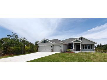 Charming single-story home with a three car garage and well-manicured lawn at 13236 Pace Cir, Port Charlotte, FL 33981