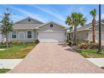 Charming one-story home featuring a brick driveway, attached garage, and well-maintained landscaping at 16079 Bandermill Dr, Port Charlotte, FL 33953