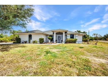 A charming single-story home features a well-maintained lawn and a welcoming entrance, perfect for a serene living at 17210 Chase Ave, Port Charlotte, FL 33948